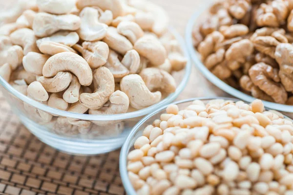 Three Glass Cups Walnuts Cashews Pine Nuts Bamboo Table Cloth — Stock Photo, Image