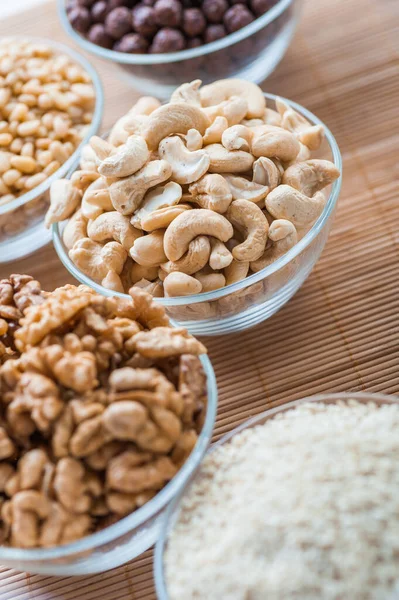 Fünf Glasschalen Mit Weißem Sesam Walnüssen Cashewnüssen Pinienkernen Und Schokokugeln — Stockfoto