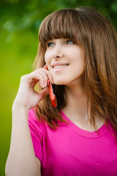 Mulher Bonita Uma Camiseta Rosa Falando Telefone Celular Vermelho Contra — Fotografia de Stock