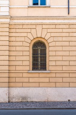 Tuğla, penceresi ve metal kafesleri olan eski bina duvarı..