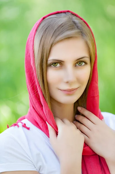 夏の緑の都市公園を背景に白いブラウスと赤いスカーフで若い魅力的な笑顔の女性 — ストック写真