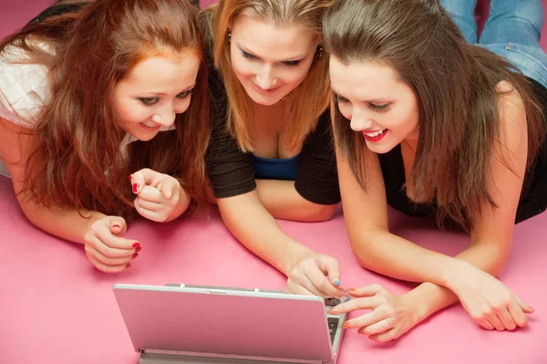 三个年轻女孩笑着看笔记本电脑 — 图库照片