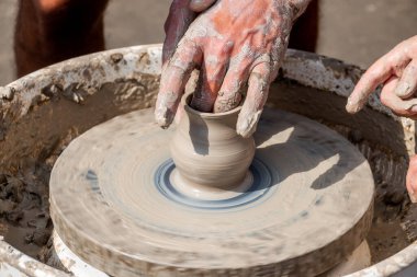 Seramik çömlek ustası dönen bir kil diski üzerinde küçük, güzel bir sürahi yapar. El yapımı. Yerel Folklor Tasarımı.