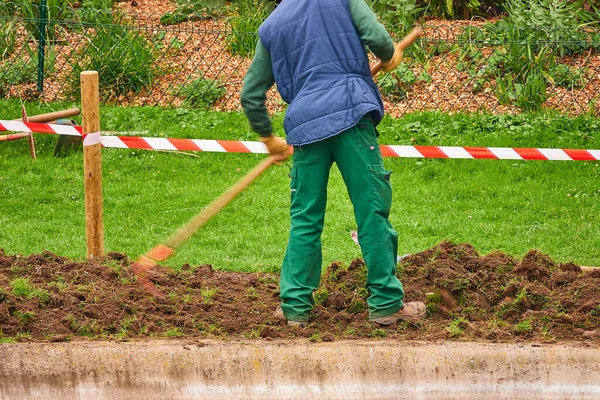 Trabajador Utiliza Azada Para Procesar Tierra Parque Ciudad — Foto de Stock