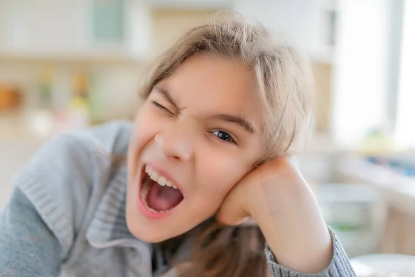 Uma Menina Adolescente Loira Bonita Alegre Uma Camisola Cinza Boceja — Fotografia de Stock