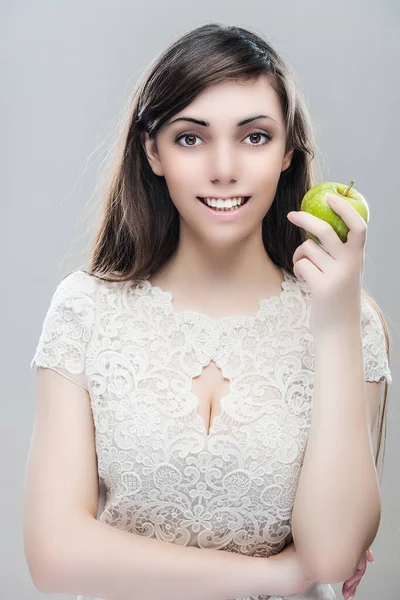 Молода Усміхнена Красива Дівчина Довгим Волоссям Тримає Зелене Яблуко Сірому — стокове фото