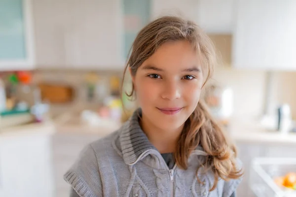 Gri Kazaklı Gülümseyen Güzel Bir Sarışın Kız Mutfaktaki Masada Oturuyor — Stok fotoğraf