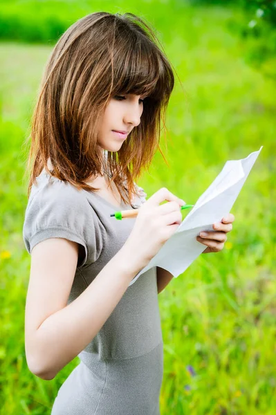 Een Mooie Jonge Vrouw Schrijft Een Pen Een Stuk Papier Stockfoto