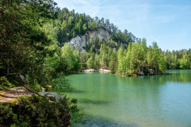 Adrıspanak Göleti. Adrspach-Teplice Kayaları, Çek Cumhuriyeti 'nin kuzeydoğusundaki Bohemya' da sıradışı bir kumtaşı oluşumlarıdır. Adrspach ve Teplice nad Metuji olmak üzere iki belediyeden sonra isimlendirilmişlerdir..