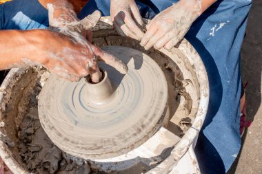 Çömlek ustası öğrenciyi kilden küçük bir sürahi yapmaya teşvik ediyor. Kil tabak yapmak için bir pikap. El yapımı..