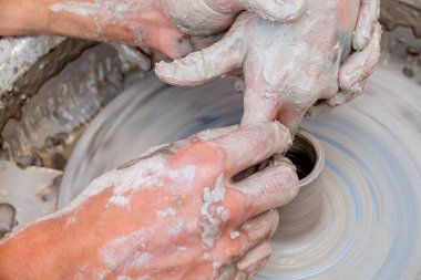 Çömlek ustası öğrenciyi kilden küçük bir sürahi yapmaya teşvik ediyor. Kil tabak yapmak için bir pikap. El yapımı..