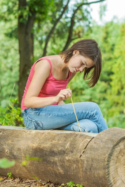 Chica al aire libre en el bosque sentado en el registro — Foto de Stock