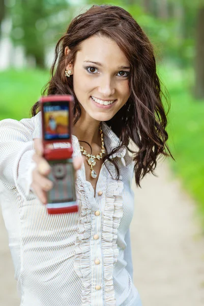 Menina estende telefone celular — Fotografia de Stock