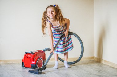 Elektrikli süpürge ile gülümseyen kız