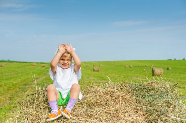Samanlık üzerinde küçük kız.