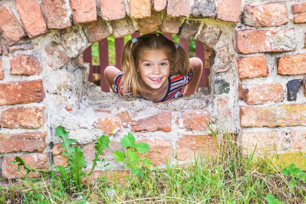 오래 된 벽돌 건물에 어린 소녀 — 스톡 사진