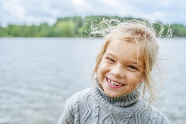 Маленькая веселая девочка в свитере — стоковое фото
