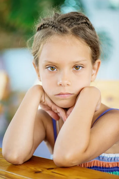 Маленька дівчинка сидить за столом — стокове фото