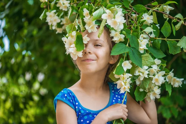 Ragazza sorridente vicino gelsomino in fiore — Foto Stock