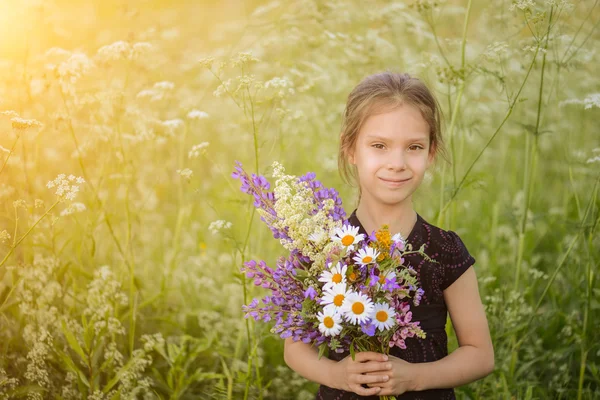 Malá dívka hospodářství květy — Stock fotografie