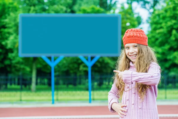 小さな女の子は、スタジアムのスコアボードに示しています。 — ストック写真