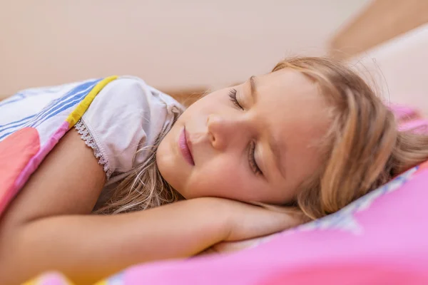 Маленькая девочка спит на кровати — стоковое фото