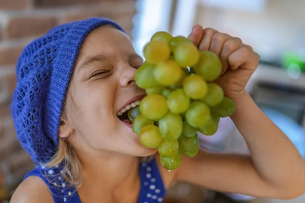 Étkezési finom szőlő boldog kislány — Stock Fotó
