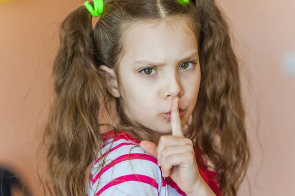 Little girl putting finger to his lips — Stock Photo, Image