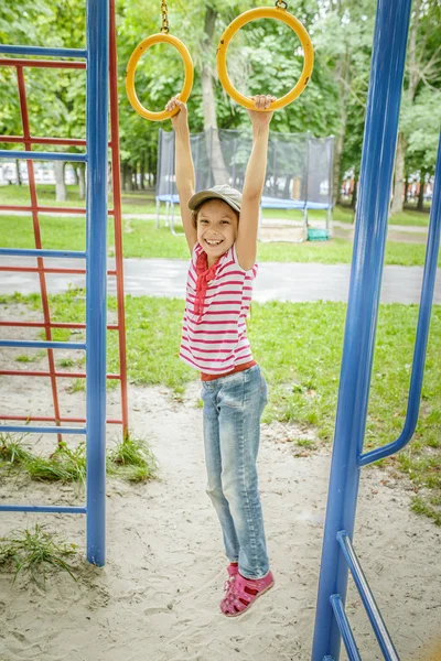 Kleines Mädchen hängt an Sportringen — Stockfoto