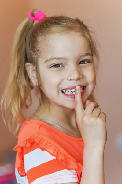 Dziewczynka kładzie palec na ustach — Zdjęcie stockowe