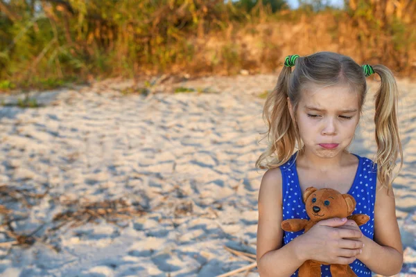 Piccola ragazza triste che tiene orsacchiotto — Foto Stock