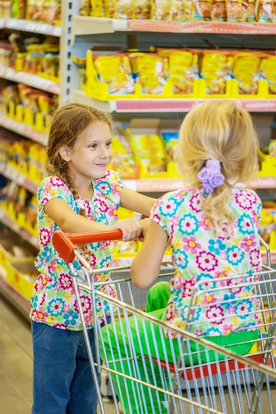 Little beautiful sisters in supermarket — Stock Photo, Image