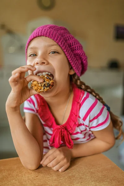 Pequeña chica hermosa comiendo caramelo de nuez —  Fotos de Stock