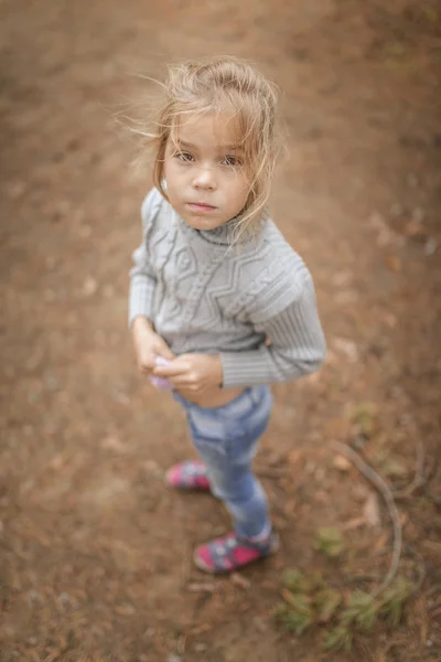Маленькая грустная девочка в свитере — стоковое фото