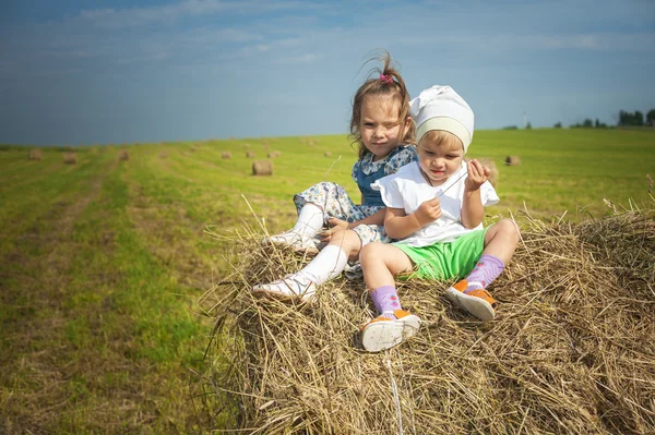 Two little sisters on haystack. — Stock Photo, Image