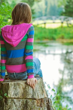 Kız saplama üzerinde oturuyor.