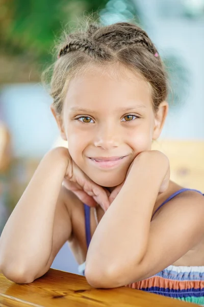 Liten flicka sitter vid bord — Stockfoto