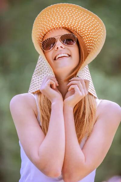 美しい広いビーチ帽子の若い女性の笑みを浮かべて — ストック写真