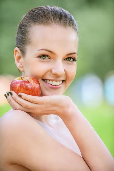 Young woman points at apple — Stock Photo, Image