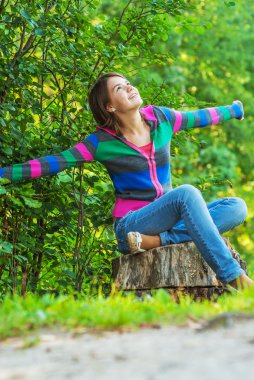 Kız saplama üzerinde oturuyor.