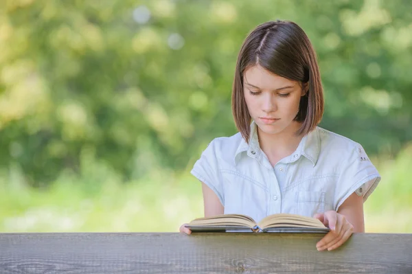 Retrato de bela leitura menina morena — Fotografia de Stock