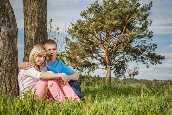 Junges Paar sitzt auf Gras — Stockfoto