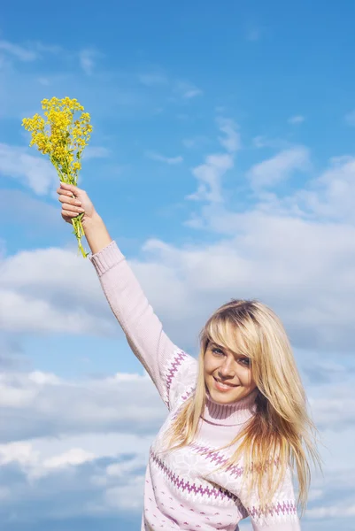 Κορίτσι με ένα μπουκέτο από κίτρινα λουλούδια κατά ουρανό — Φωτογραφία Αρχείου