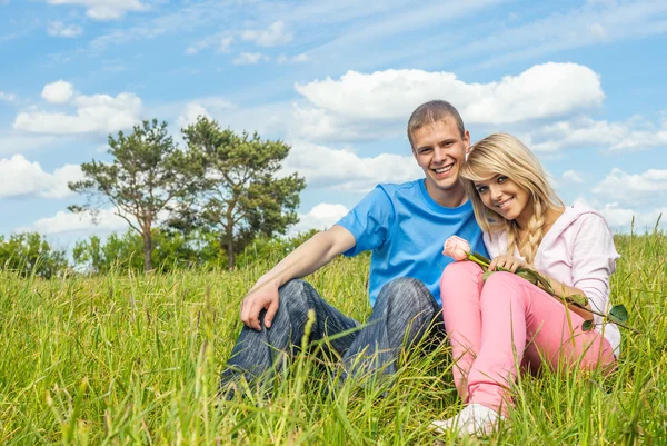 Ung man och tjejen på en äng — Stockfoto