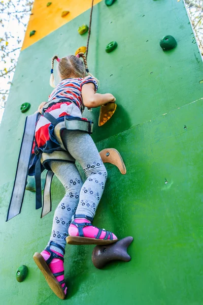 Little girl talking trains on climbing wall — Stock Photo, Image