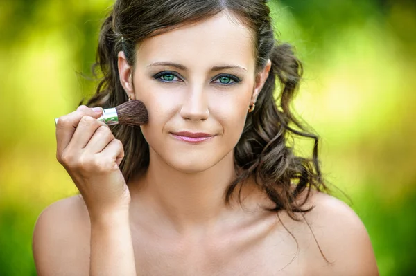 Woman puts on face powder brush — Stock Photo, Image