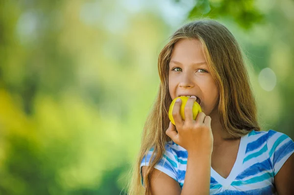 Tonårig flicka biter ett äpple — Stockfoto