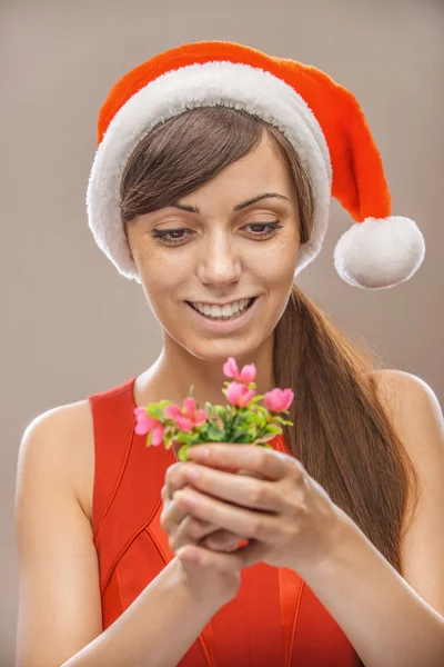 Mujer sonriente en Santa Claus ropa con flor —  Fotos de Stock