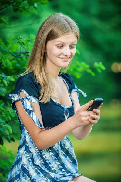 携帯電話を持つ美しい若い女性は — ストック写真