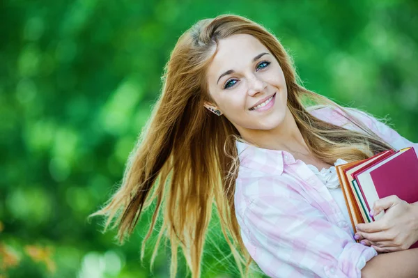 Lächelnde junge Frau mit Büchern — Stockfoto